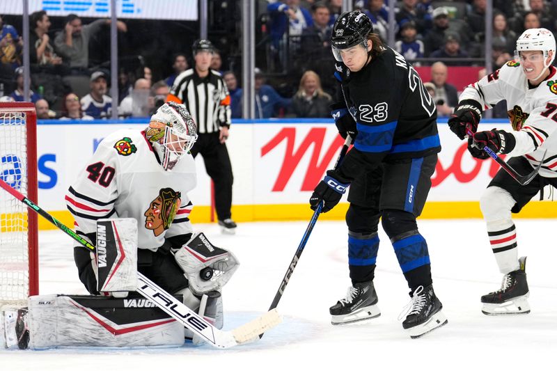 Dec 2, 2024; Toronto, Ontario, CAN; Chicago Blackhawks goaltender Arvid Soderblom (40) makes a glove save as Toronto Maple Leafs forward Matthew Knies (23) looks for a rebound during the third period at Scotiabank Arena. Mandatory Credit: John E. Sokolowski-Imagn Images