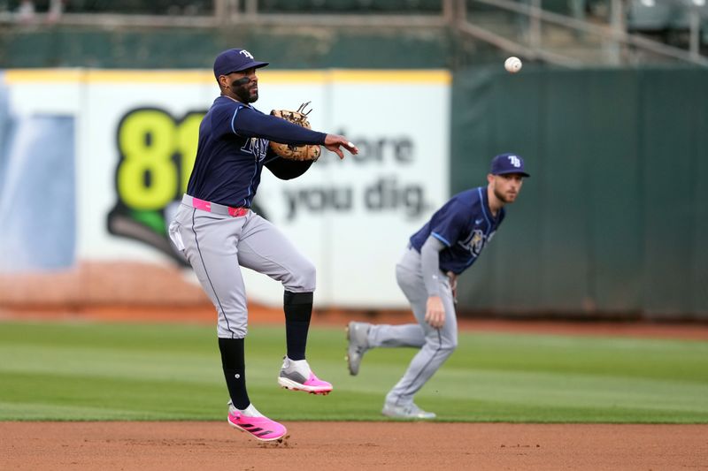 Aug 21, 2024; Oakland, California, USA; Tampa Bay Rays first baseman Yandy Diaz (2) throws the ball to first base to record an out against the Oakland Athletics during the third inning at Oakland-Alameda County Coliseum. Mandatory Credit: Darren Yamashita-USA TODAY Sports