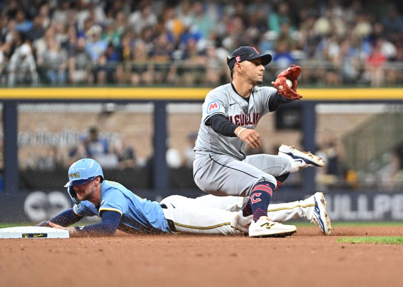 Aug 16, 2024; Milwaukee, Wisconsin, USA; Milwaukee Brewers second base Brice Turang (2) steals second base ahead of the tag by Cleveland Guardians second base Andres Gimenez (0) in the fourth inning at American Family Field. Mandatory Credit: Michael McLoone-USA TODAY Sports