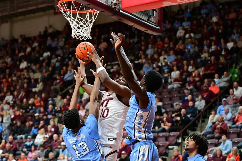 Mar 4, 2025; Blacksburg, Virginia, USA;  Virginia Tech Hokies guard Tyler Johnson (10) goes up for a shot as North Carolina Tar Heels forward Jalen Washington (13) defends during the first half at Cassell Coliseum. Mandatory Credit: Brian Bishop-Imagn Images