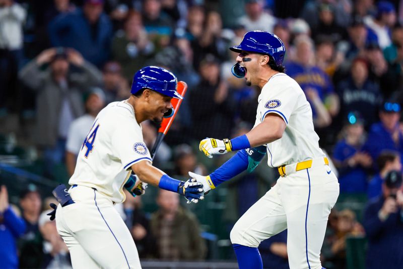 Apr 28, 2024; Seattle, Washington, USA; Seattle Mariners third baseman Josh Rojas (4, right) celebrates with center fielder Julio Rodriguez (44) after hitting a lead-off home run against the Arizona Diamondbacks during the first inning at T-Mobile Park. Mandatory Credit: Joe Nicholson-USA TODAY Sports