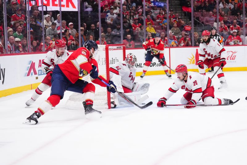 Jan 2, 2025; Sunrise, Florida, USA; Carolina Hurricanes goaltender Pyotr Kochetkov (52) saves a shot by Florida Panthers center Aleksander Barkov (16) during the third period at Amerant Bank Arena. Mandatory Credit: Rich Storry-Imagn Images