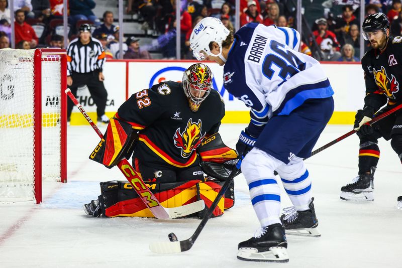 Oct 26, 2024; Calgary, Alberta, CAN; Calgary Flames goaltender Dustin Wolf (32) guards his net against Winnipeg Jets center Morgan Barron (36) during the first period at Scotiabank Saddledome. Mandatory Credit: Sergei Belski-Imagn Images