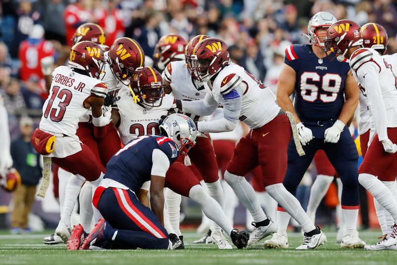 Washington Commanders safety Jartavius Martin celebrates with teammates after his interception on a pass intended for New England Patriots wide receiver JuJu Smith-Schuster (7) in the second half of an NFL football game, Sunday, Nov. 5, 2023, in Foxborough, Mass. (AP Photo/Michael Dwyer)