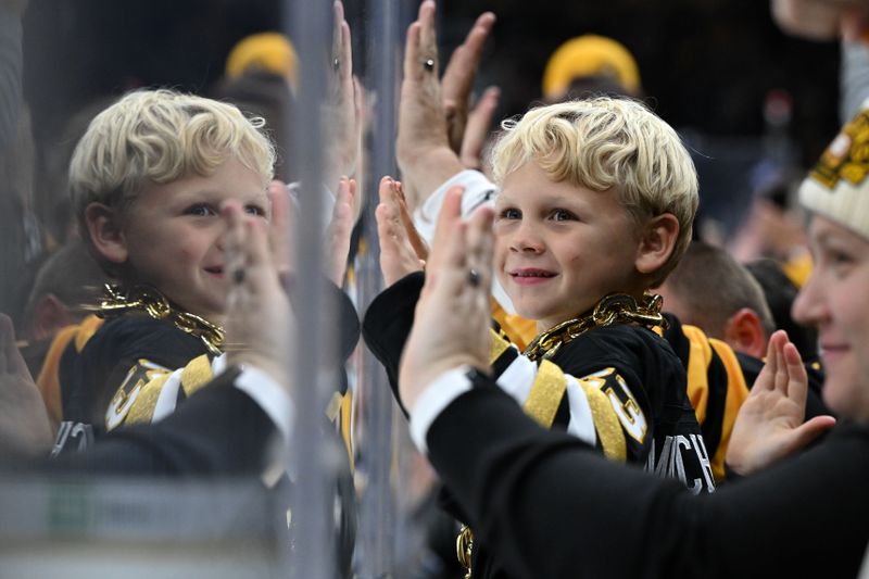 Oct 14, 2023; Boston, Massachusetts, USA; A young Boston Bruins fan cheers after a goal was scored against the Nashville Predators during the first period at the TD Garden. Mandatory Credit: Brian Fluharty-USA TODAY Sports