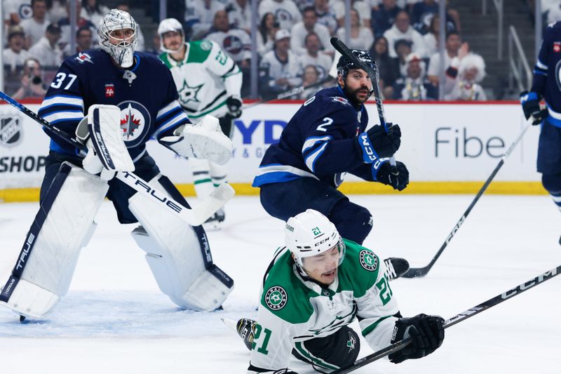 May 15, 2025; Winnipeg, Manitoba, CAN; Winnipeg Jets defenseman Dylan DeMelo (2) bodies Dallas Stars forward Jason Robertson (21) during the first period in game five of the second round of the 2025 Stanley Cup Playoffs at Canada Life Centre. Mandatory Credit: Terrence Lee-Imagn Images
