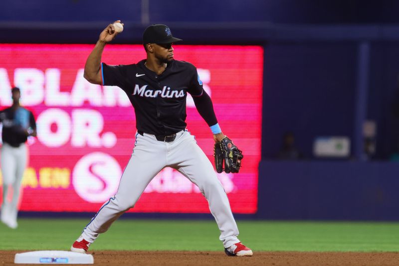 Jun 21, 2024; Miami, Florida, USA; Miami Marlins second baseman Otto Lopez (61) throws to first base to retire Seattle Mariners third base coach Manny Acta (not pictured) during the fourth inning at loanDepot Park. Mandatory Credit: Sam Navarro-USA TODAY Sports