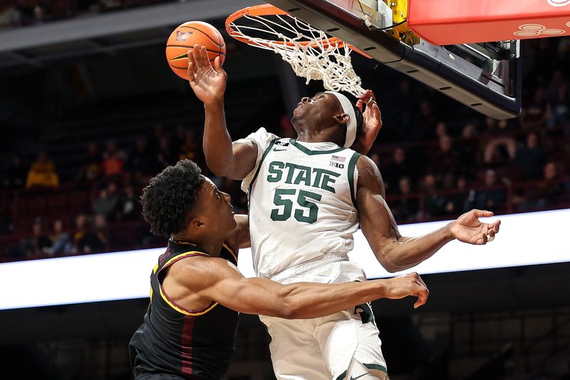 Dec 4, 2024; Minneapolis, Minnesota, USA; Michigan State Spartans forward Coen Carr (55) blocks a dunk by Minnesota Golden Gophers center Trey Edmonds (5) during the first half at Williams Arena. Mandatory Credit: Matt Krohn-Imagn Images