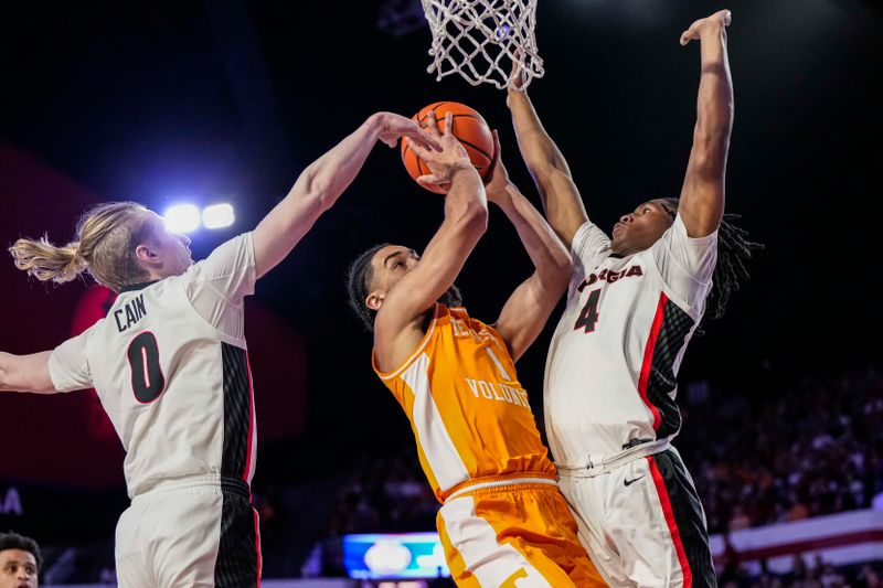 Jan 13, 2024; Athens, Georgia, USA; Tennessee Volunteers guard Freddie Dilione V (1) is defended by Georgia Bulldogs guard Blue Cain (0) and guard Silas Demary Jr. (4) during the first half at Stegeman Coliseum. Mandatory Credit: Dale Zanine-USA TODAY Sports