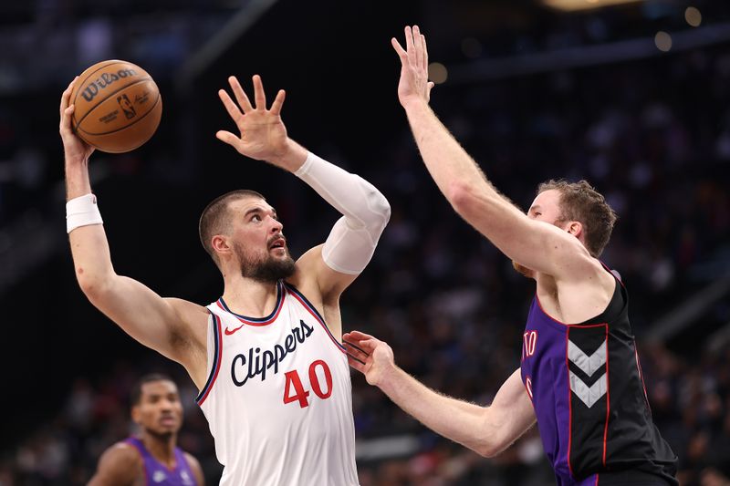 INGLEWOOD, CALIFORNIA - NOVEMBER 09: Ivica Zubac #40 of the LA Clippers shoots over the defense of Jakob Poeltl #19 of the Toronto Raptors for a rebound during the second half of a game at Intuit Dome on November 09, 2024 in Inglewood, California. NOTE TO USER: User expressly acknowledges and agrees that, by downloading and/or using this photograph, user is consenting to the terms and conditions of the Getty Images License Agreement. (Photo by Sean M. Haffey/Getty Images)