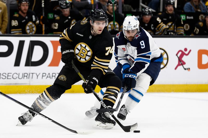 Jan 22, 2024; Boston, Massachusetts, USA; Winnipeg Jets left wing Alex Iafallo (9) tries to slow down Boston Bruins left wing Jake DeBrusk (74) during the second period at TD Garden. Mandatory Credit: Winslow Townson-USA TODAY Sports