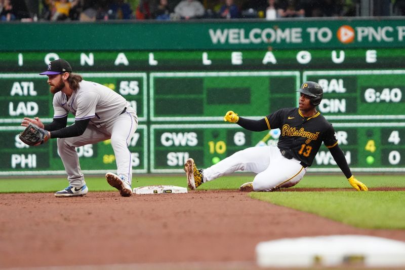 May 4, 2024; Pittsburgh, Pennsylvania, USA; Pittsburgh Pirates third baseman Ke'Bryan Hayes (13) slides into second base with a double ahead of the throw received by Colorado Rockies second baseman Brendan Rodgers (7) during the sixth inning at PNC Park. Mandatory Credit: Gregory Fisher-USA TODAY Sports