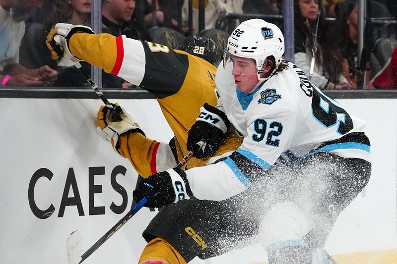 Sep 27, 2024; Las Vegas, Nevada, USA; Utah Hockey Club forward Logan Cooley (92) checks Vegas Golden Knights center Tanner Laczynski (28) during the second period at T-Mobile Arena. Mandatory Credit: Stephen R. Sylvanie-Imagn Images