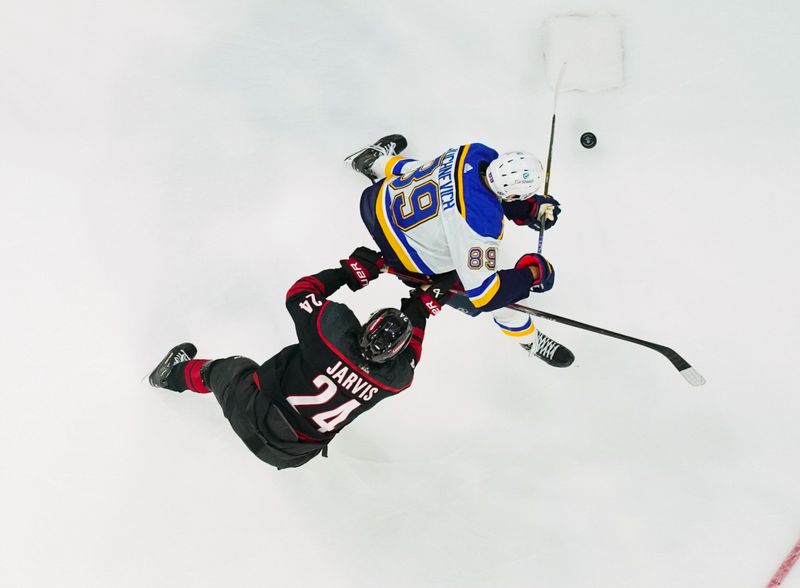 Jan 6, 2024; Raleigh, North Carolina, USA; St. Louis Blues left wing Pavel Buchnevich (89) skates with the puck against Carolina Hurricanes center Seth Jarvis (24) during the third period at PNC Arena. Mandatory Credit: James Guillory-USA TODAY Sports