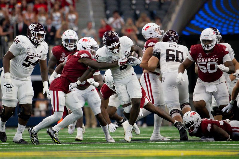 Sep 30, 2023; Arlington, Texas, USA; Texas A&M Aggies running back Le'Veon Moss (8) runs through the Arkansas Razorbacks defensive line during the second half at AT&T Stadium. Mandatory Credit: Jerome Miron-USA TODAY Sports