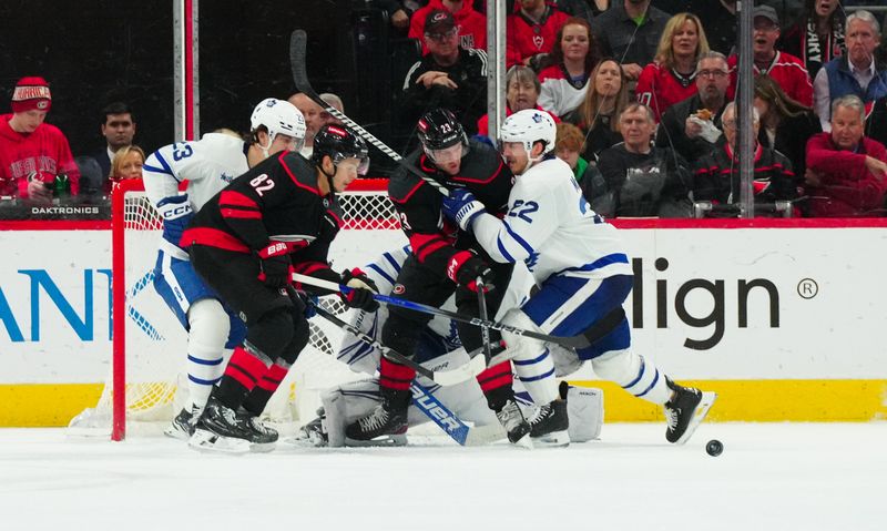 Mar 24, 2024; Raleigh, North Carolina, USA;  Toronto Maple Leafs defenseman Jake McCabe (22) clears Carolina Hurricanes right wing Stefan Noesen (23) from the puck during the second period at PNC Arena. Mandatory Credit: James Guillory-USA TODAY Sports