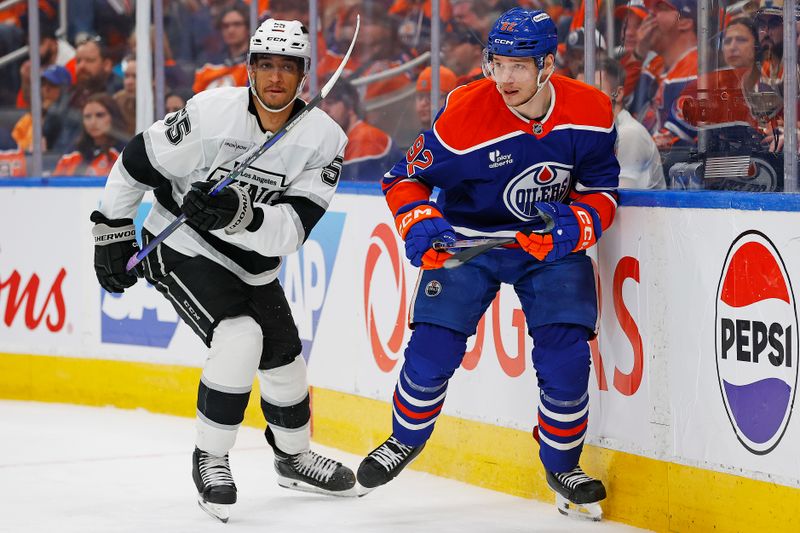Apr 27, 2025; Edmonton, Alberta, CAN;Edmonton Oilers forward Vasily Podkolzin (92) and Los Angeles Kings forward Quinton Byfield (55) looks for a loose puck during the third period in game four of the first round of the 2025 Stanley Cup Playoffs at Rogers Place. Mandatory Credit: Perry Nelson-Imagn Images