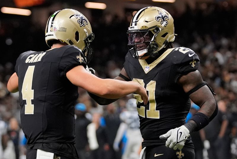 New Orleans Saints running back Jamaal Williams (21) celebrates a touchdown with quarterback Derek Carr (4) during the second half of an NFL football game against the Carolina Panthers, Sunday, Sept. 8, 2024, in New Orleans. (AP Photo/Gerald Herbert)