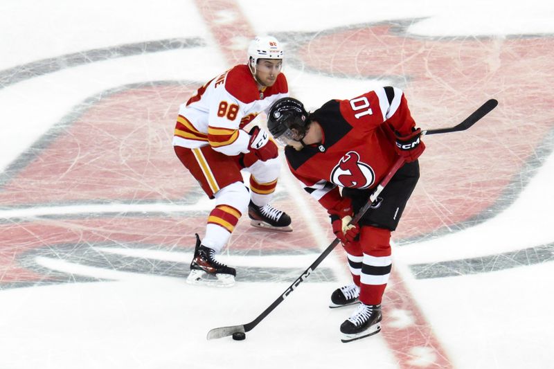 Feb 8, 2024; Newark, New Jersey, USA; New Jersey Devils right wing Alexander Holtz (10) skates with the puck against Calgary Flames left wing Andrew Mangiapane (88) during the third period at Prudential Center. Mandatory Credit: John Jones-USA TODAY Sports