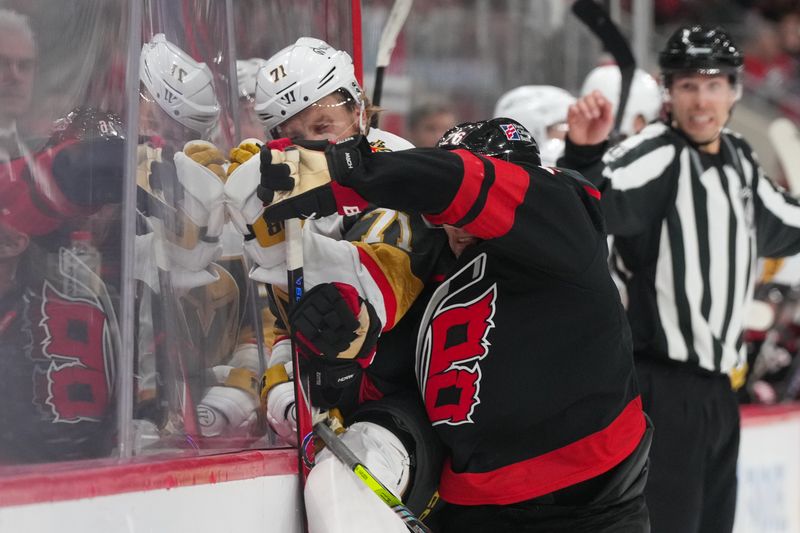 Oct 28, 2025; Raleigh, North Carolina, USA;  Carolina Hurricanes defenseman Sean Walker (26) checks Vegas Golden Knights center William Karlsson (71) during the second period at Lenovo Center. Mandatory Credit: James Guillory-Imagn Images
