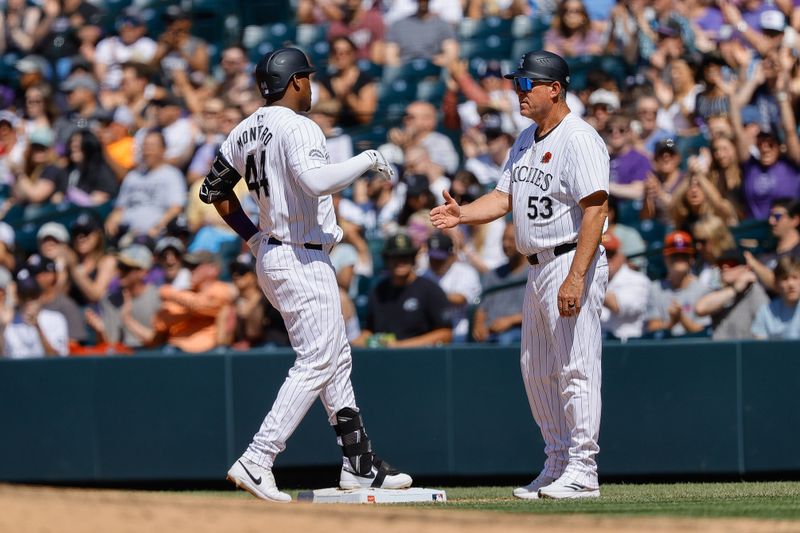 May 27, 2024; Denver, Colorado, USA; Colorado Rockies first baseman Elehuris Montero (44) reacts with first base coach Ronnie Gideon (53) after hitting a two RBI single in the fourth inning against the Cleveland Guardians at Coors Field. Mandatory Credit: Isaiah J. Downing-USA TODAY Sports