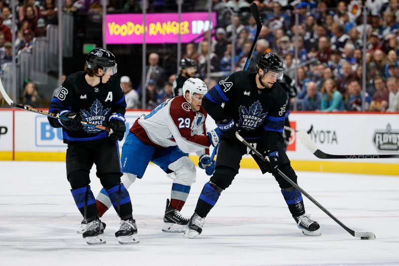 Feb 24, 2024; Denver, Colorado, USA; Toronto Maple Leafs center Auston Matthews (34) controls the puck ahead of Colorado Avalanche center Nathan MacKinnon (29) as right wing Mitchell Marner (16) looks on in the first period at Ball Arena. Mandatory Credit: Isaiah J. Downing-USA TODAY Sports