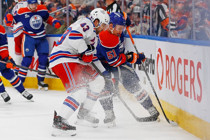 Oct 30, 2025; Edmonton, Alberta, CAN; Edmonton Oilers defensemen Troy Stecher (51) and New York Rangers forward Connor Sheary (43) battle along the boards for a loose puck during the second period at Rogers Place. Mandatory Credit: Perry Nelson-Imagn Images