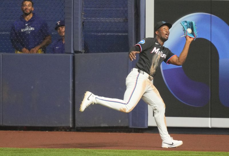 May 31, 2024; Miami, Florida, USA;  Miami Marlins right fielder Jesús Sánchez (12) makes a running catch against the Texas Rangers in the fifth inning at loanDepot Park. Mandatory Credit: Jim Rassol-USA TODAY Sports