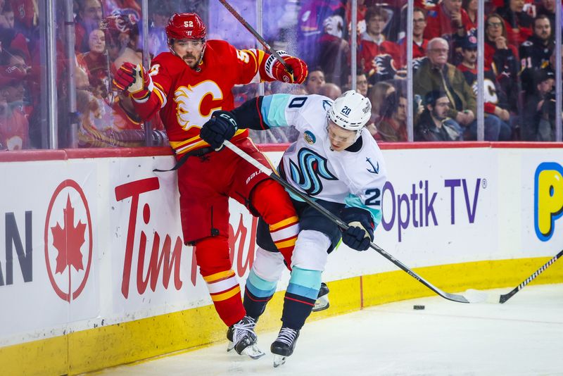 Dec 27, 2023; Calgary, Alberta, CAN; Calgary Flames defenseman MacKenzie Weegar (52) and Seattle Kraken right wing Eeli Tolvanen (20) battle for the puck during the third period at Scotiabank Saddledome. Mandatory Credit: Sergei Belski-USA TODAY Sports