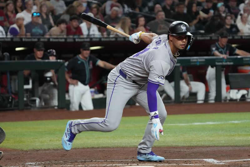 Aug 12, 2024; Phoenix, Arizona, USA; Colorado Rockies shortstop Ezequiel Tovar (14) reacts after lunging at a ball aginst the Arizona Diamondbacks in the first inning at Chase Field. Mandatory Credit: Rick Scuteri-USA TODAY Sports