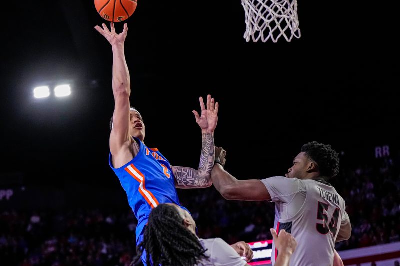 Feb 17, 2024; Athens, Georgia, USA; Florida Gators guard Riley Kugel (2) shoots over Georgia Bulldogs center Russel Tchewa (54) during the second half at Stegeman Coliseum. Mandatory Credit: Dale Zanine-USA TODAY Sports