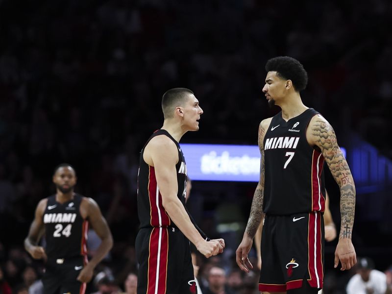MIAMI, FLORIDA - APRIL 03: Tyler Herro (C) #14 of the Miami Heat and teammate Kel'el Ware #7 react during the third quarter against the Memphis Grizzlies at Kaseya Center on April 03, 2025 in Miami, Florida. NOTE TO USER: User expressly acknowledges and agrees that, by downloading and or using this photograph, User is consenting to the terms and conditions of the Getty Images License Agreement. (Photo by Brennan Asplen/Getty Images)