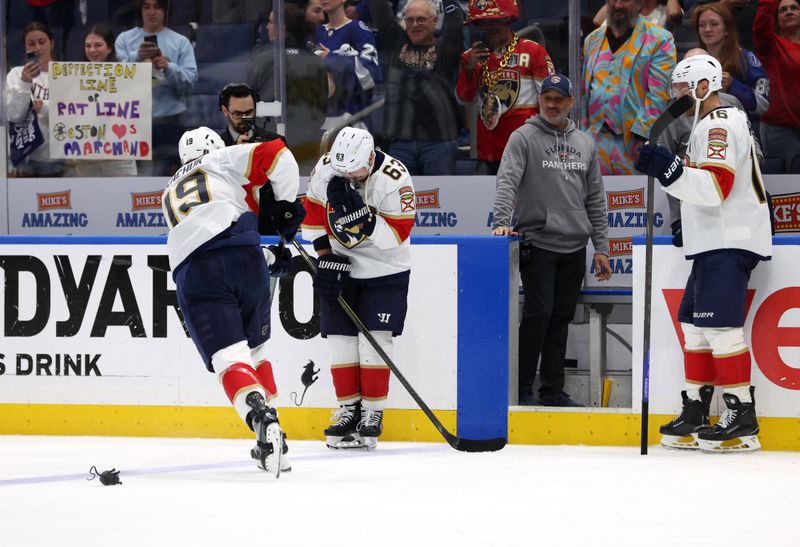 Apr 30, 2025; Tampa, Florida, USA; Florida Panthers left wing Matthew Tkachuk (19) passes a rat onto center Brad Marchand (63) after they beat the Tampa Bay Lightning during the third period of game five of the first round of the 2025 Stanley Cup Playoffs at Amalie Arena. Mandatory Credit: Kim Klement Neitzel-Imagn Images