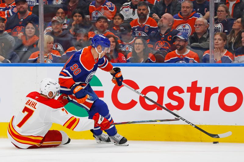 Oct 13, 2024; Edmonton, Alberta, CAN; Edmonton Oilers forward Corey Perry (90) carries the puck around Calgary Flames defensemen Kevin Bahl (7) during the third period at Rogers Place. Mandatory Credit: Perry Nelson-Imagn Images