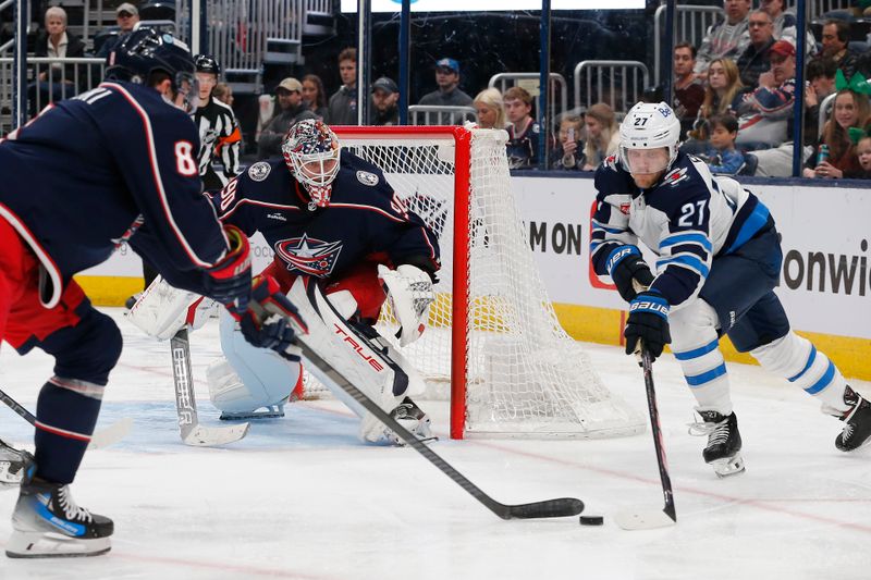 Mar 17, 2024; Columbus, Ohio, USA; Winnipeg Jets left wing Nikolaj Ehlers (27) and Columbus Blue Jackets defenseman Zach Werenski (8) reach for a loose puck during the third period at Nationwide Arena. Mandatory Credit: Russell LaBounty-USA TODAY Sports