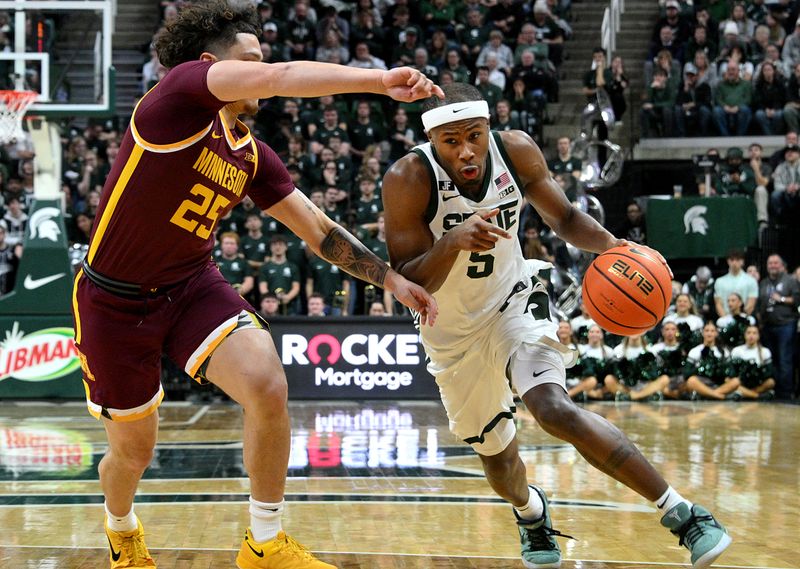 Jan 28, 2025; East Lansing, Michigan, USA;  Michigan State Spartans guard Tre Holloman (5) drives past Minnesota Golden Gophers guard Lu'Cye Patterson (25) during the second half at Jack Breslin Student Events Center. Mandatory Credit: Dale Young-Imagn Images