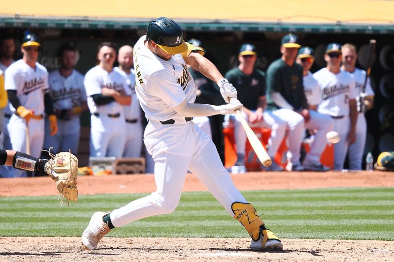 May 23, 2024; Oakland, California, USA; Oakland Athletics shortstop Max Shuemann (12) hits a single against the Colorado Rockies during the ninth inning at Oakland-Alameda County Coliseum. Mandatory Credit: Kelley L Cox-USA TODAY Sports