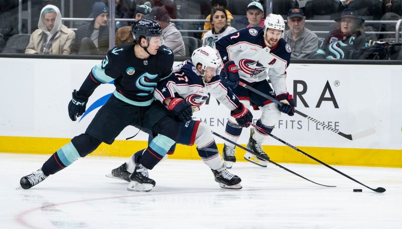 Jan 28, 2024; Seattle, Washington, USA; Seattle Kraken defenseman Will Borgen (3), left, and Columbus Blue Jackets forward Justin Danforth (17) battle for the puck during the third period at Climate Pledge Arena. Mandatory Credit: Stephen Brashear-USA TODAY Sports