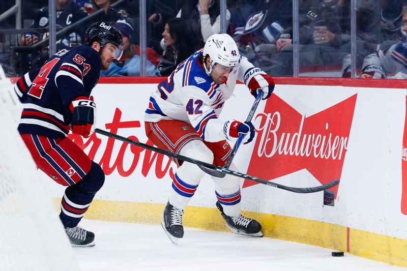 Mar 12, 2026; Winnipeg, Manitoba, CAN;  New York Rangers forward Noah Laba (42) and Winnipeg Jets defenseman Dylan Samberg (54) battle for the puck during the first period at Canada Life Centre. Mandatory Credit: Terrence Lee-Imagn Images