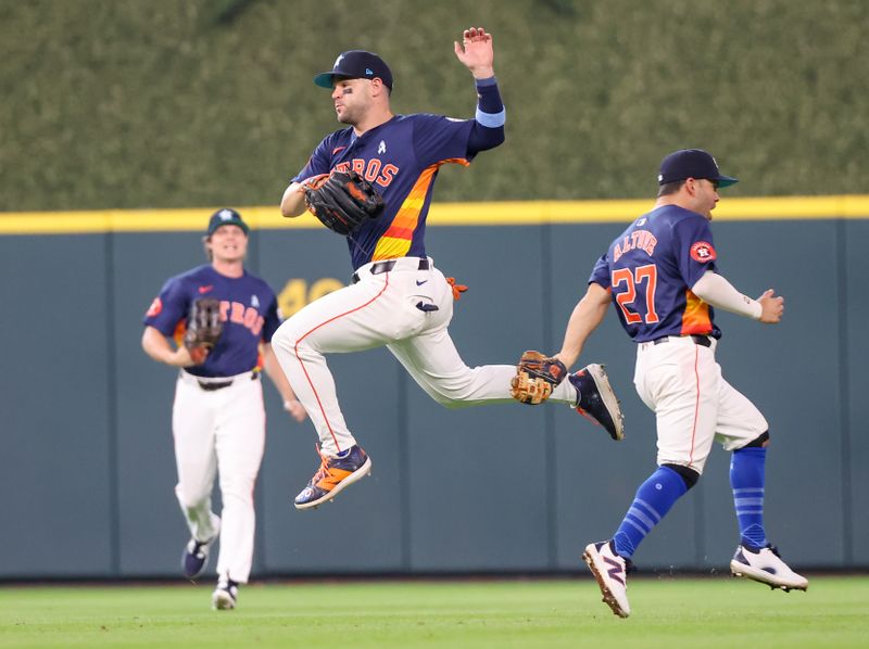 Jun 16, 2024; Houston, Texas, USA; Houston Astros center fielder Chas McCormick (20) avoids second baseman Jose Altuve (27) after Altuve made a catch for an out against the Detroit Tigers in the eight inning at Minute Maid Park. Mandatory Credit: Thomas Shea-USA TODAY Sports