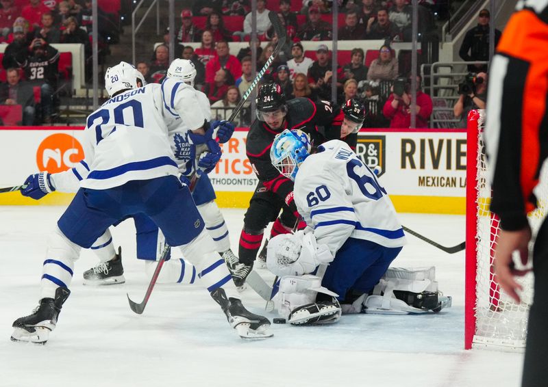 Mar 24, 2024; Raleigh, North Carolina, USA;  aToronto Maple Leafs goaltender Joseph Woll (60) stops the scoring attempt by Carolina Hurricanes center Seth Jarvis (24) during the first period t PNC Arena. Mandatory Credit: James Guillory-USA TODAY Sports