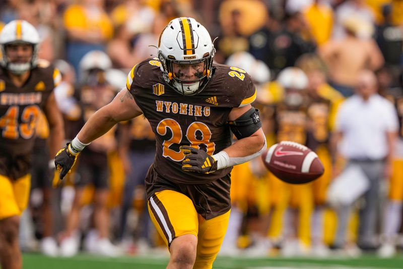 Sep 30, 2023; Laramie, Wyoming, USA; Wyoming Cowboys linebacker Easton Gibbs (28) looks to pick up a loose ball against the New Mexico Lobos during the third quarter at Jonah Field at War Memorial Stadium. Mandatory Credit: Troy Babbitt-USA TODAY Sports

