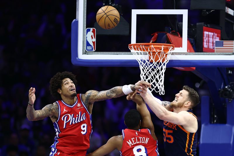 PHILADELPHIA, PENNSYLVANIA - APRIL 28: Isaiah Hartenstein #55 of the New York Knicks challenges for the ball with Kelly Oubre Jr. #9 and De'Anthony Melton #8 of the Philadelphia 76ers during the second quarter of game four of the Eastern Conference First Round Playoffs at the Wells Fargo Center on April 28, 2024 in Philadelphia, Pennsylvania. NOTE TO USER: User expressly acknowledges and agrees that, by downloading and/or using this Photograph, user is consenting to the terms and conditions of the Getty Images License Agreement. (Photo by Tim Nwachukwu/Getty Images)