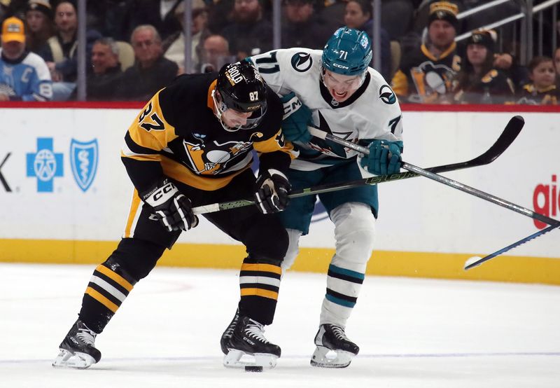 Nov 16, 2024; Pittsburgh, Pennsylvania, USA;  Pittsburgh Penguins center Sidney Crosby (87) and San Jose Sharks center Macklin Celebrini (71) battle to control the puck during the third period at PPG Paints Arena. Mandatory Credit: Charles LeClaire-Imagn Images