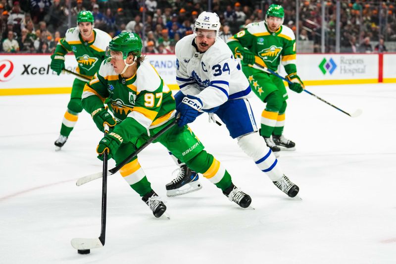 Nov 3, 2024; Saint Paul, Minnesota, USA; Minnesota Wild left wing Kirill Kaprizov (97) protects the puck from Toronto Maple Leafs center Auston Matthews (34) during the first period at Xcel Energy Center. Mandatory Credit: Brace Hemmelgarn-Imagn Images