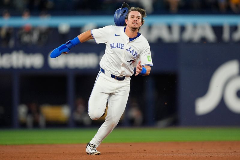 Sep 10, 2025; Toronto, Ontario, CAN; Toronto Blue Jays third baseman Addison Barger (47) loses his helmet as he runs to third base on a double hit by shortstop Ernie Clement (22) against the Houston Astros during the second inning at Rogers Centre. Mandatory Credit: John E. Sokolowski-Imagn Images