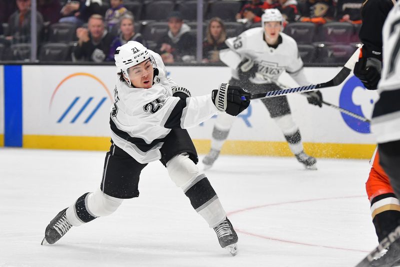 Nov 29, 2024; Anaheim, California, USA; Los Angeles Kings defenseman Jordan Spence (21) shoots on goal against the Anaheim Ducks during the first period at Honda Center. Mandatory Credit: Gary A. Vasquez-Imagn Images