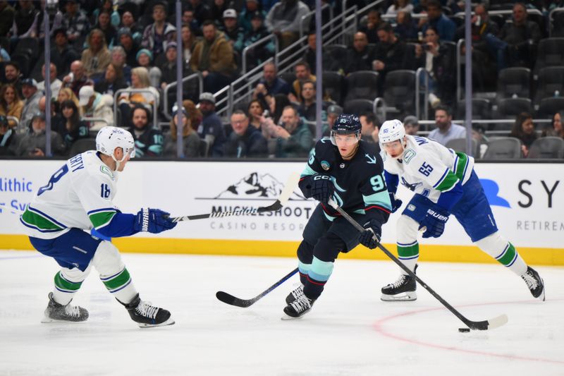 Feb 22, 2024; Seattle, Washington, USA; Seattle Kraken left wing Andre Burakovsky (95) plays the puck while defending Vancouver Canucks center Sam Lafferty (18) during the third period at Climate Pledge Arena. Mandatory Credit: Steven Bisig-USA TODAY Sports