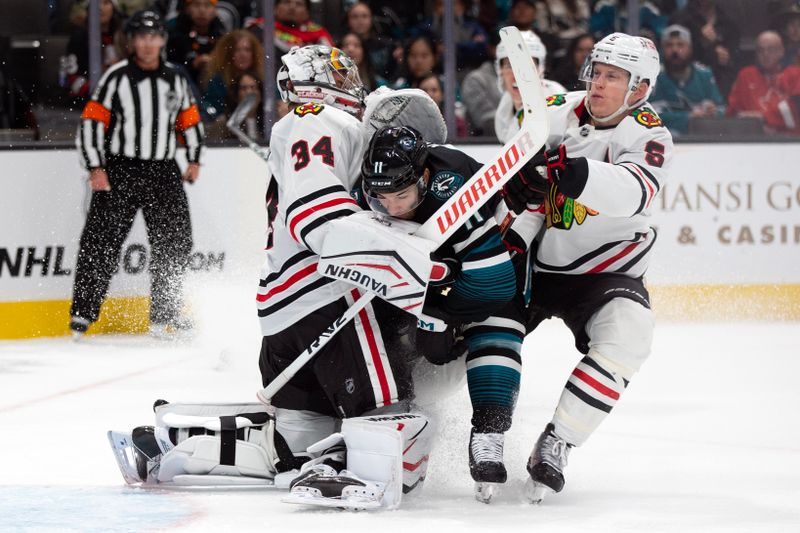 Oct 31, 2024; San Jose, California, USA; San Jose Sharks center Luke Kunin (11) collides with Chicago Blackhawks goaltender Petr Mrazek (34) and defenseman Connor Murphy (5) during the second period at SAP Center at San Jose. Mandatory Credit: D. Ross Cameron-Imagn Images