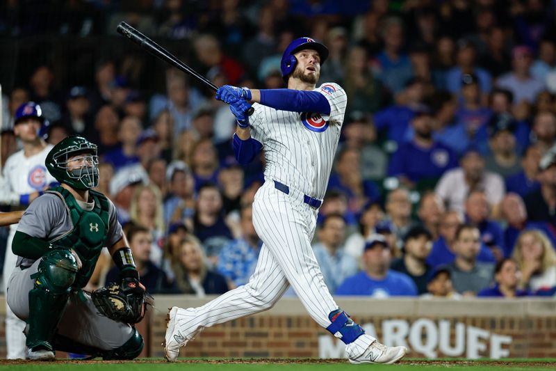 Sep 17, 2024; Chicago, Illinois, USA; Chicago Cubs first baseman Michael Busch (29) hits an RBI-single against the Oakland Athletics during the third inning at Wrigley Field. Mandatory Credit: Kamil Krzaczynski-Imagn Images